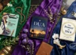 Luxury flat-lay of three Islamic books—The Productive Muslim, Du'a, and The Power of Du'a—arranged on emerald, violet, and blue silk over a black marble table with prayer beads and lanterns.